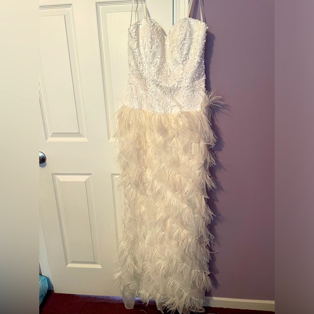 Wedding gown. Strapless, sequins top, feathered skirt. Zipper back.